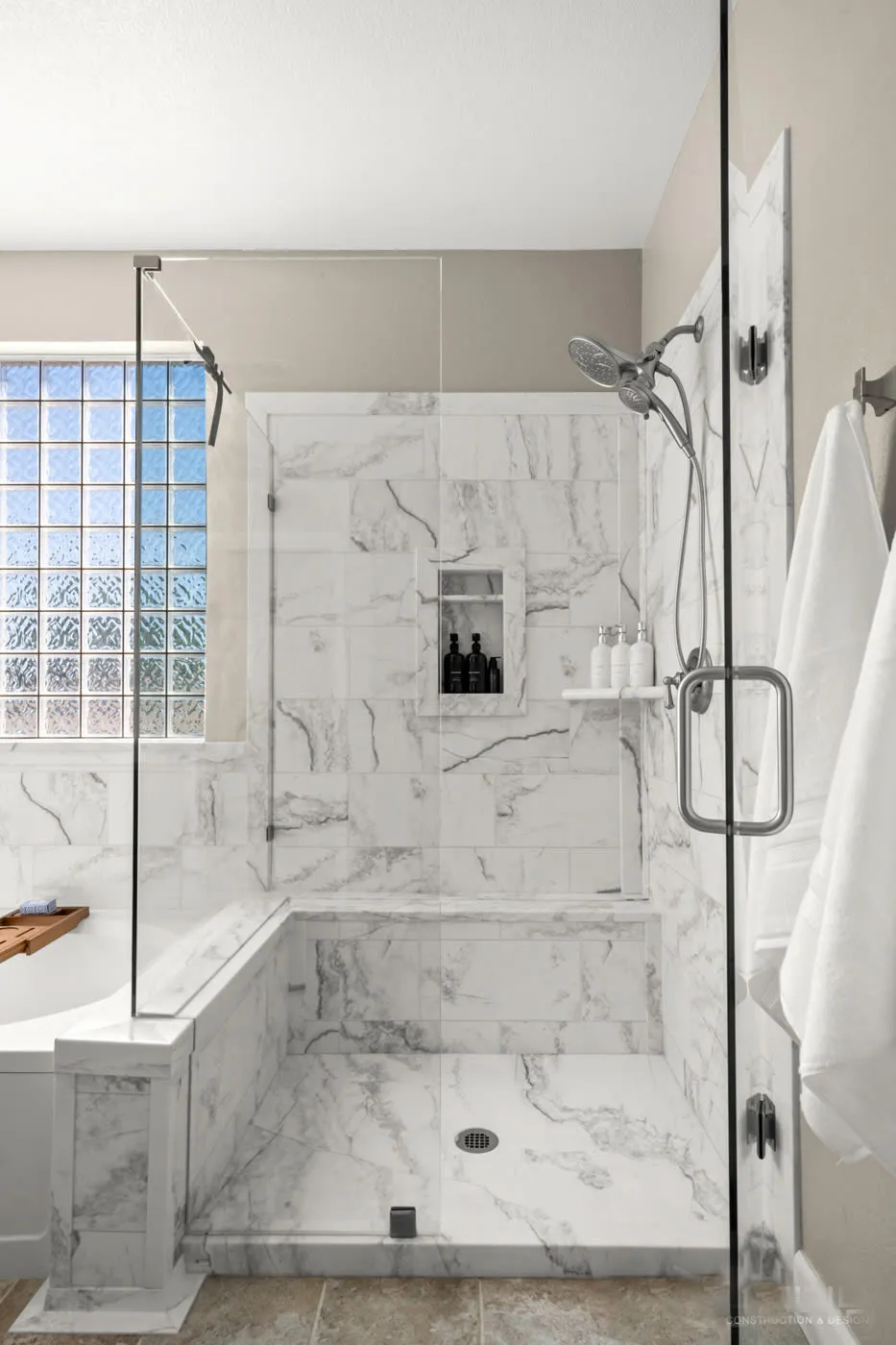 Portrait view into the glass-enclosed marble shower