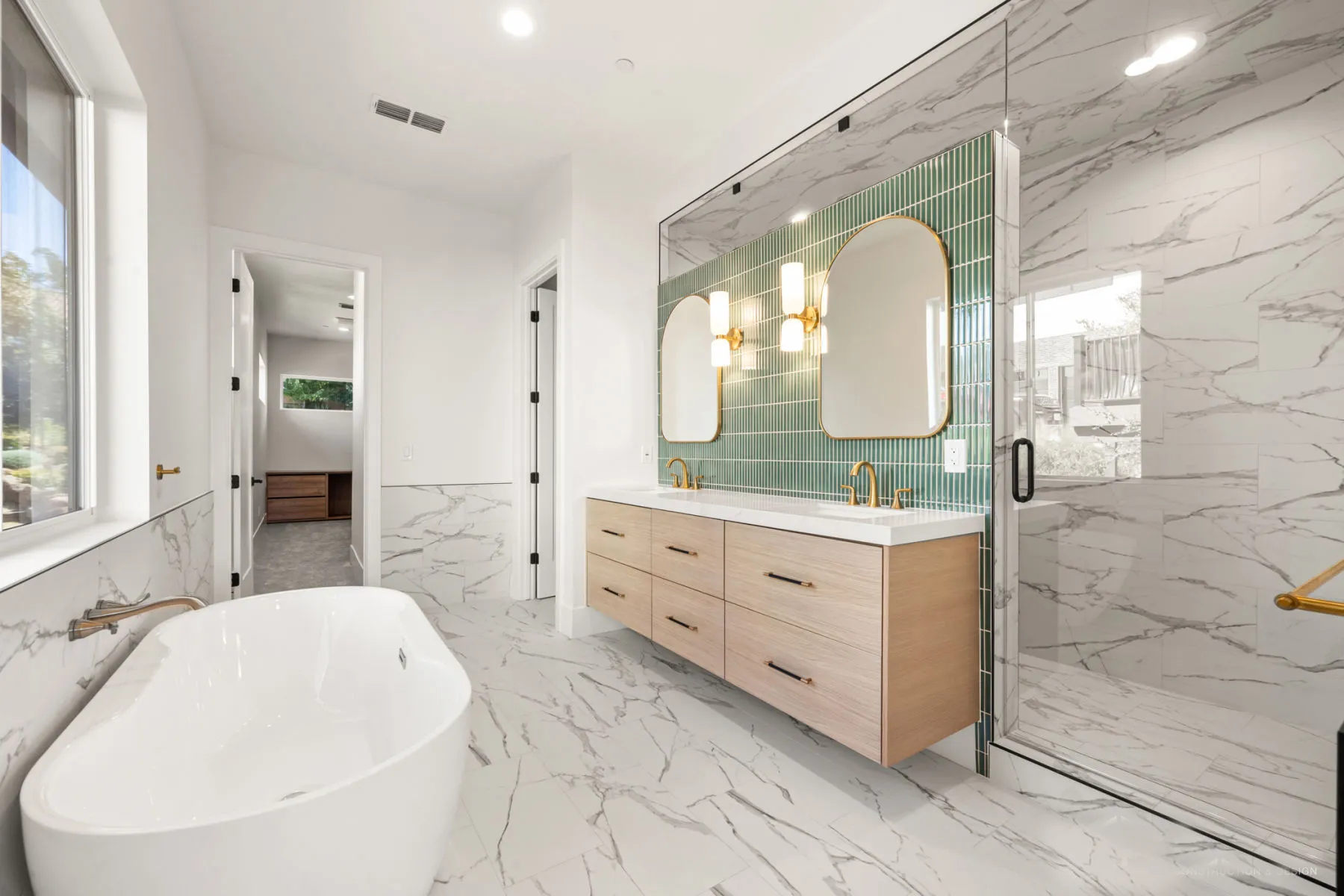 Bathroom with a freestanding tub, oak vanity, green tile, and glass shower