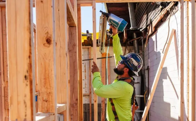 Workers coordinating utilities within an open framed wall