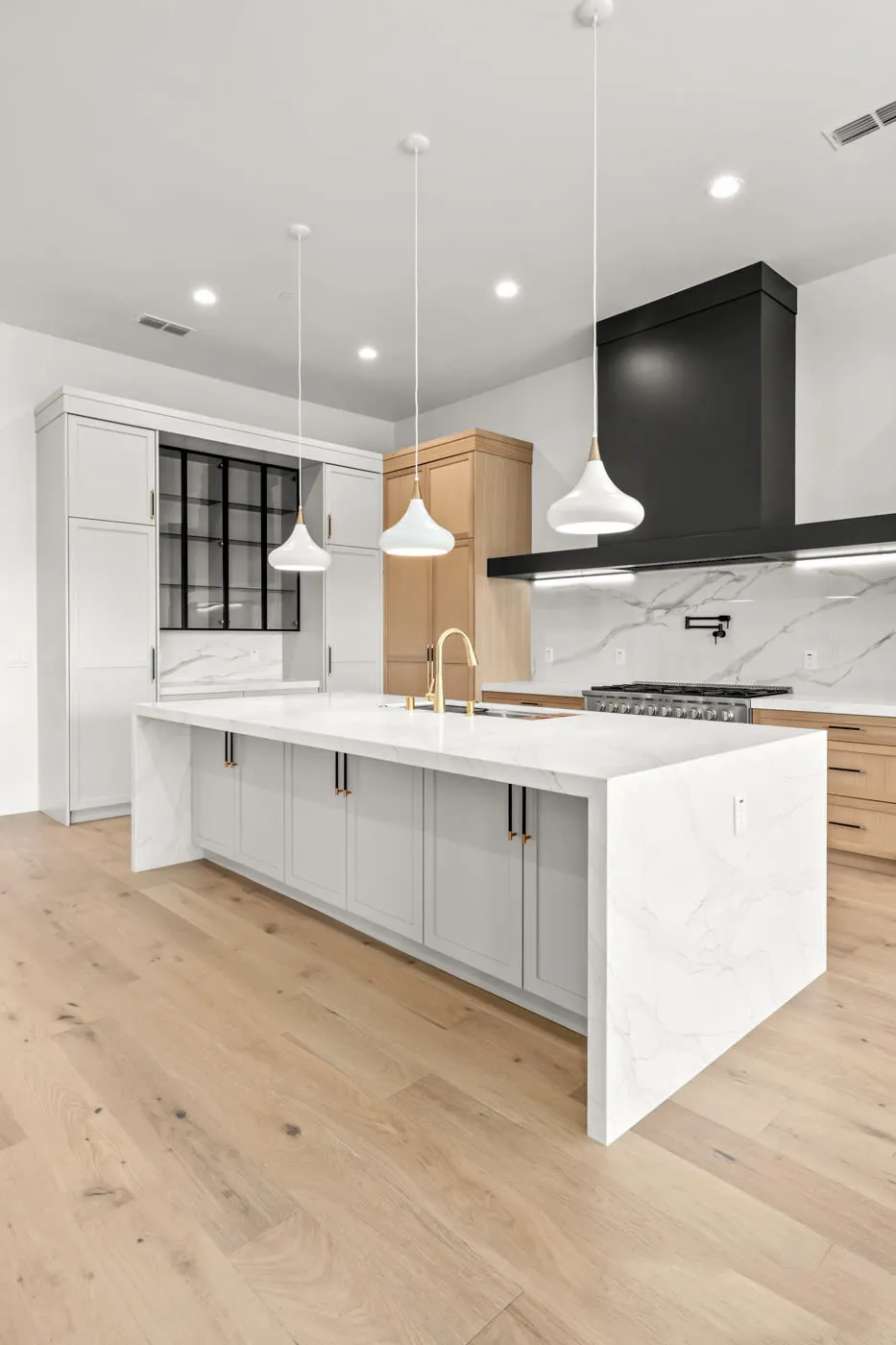 Portrait view of the waterfall island and contrasting black range hood