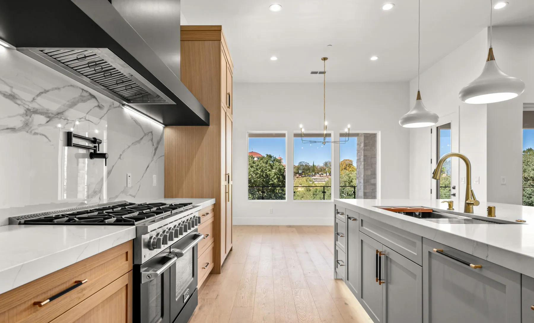 Close view past the range toward the island sink and dining windows